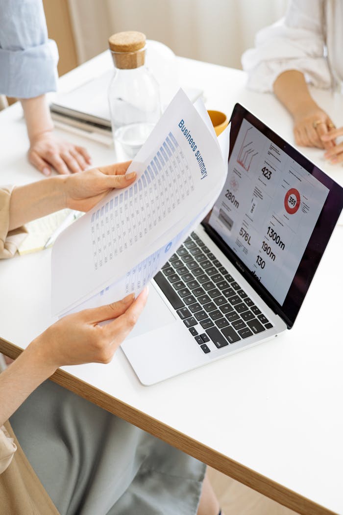 Modern office setting with a business report and laptop display on a white desk.